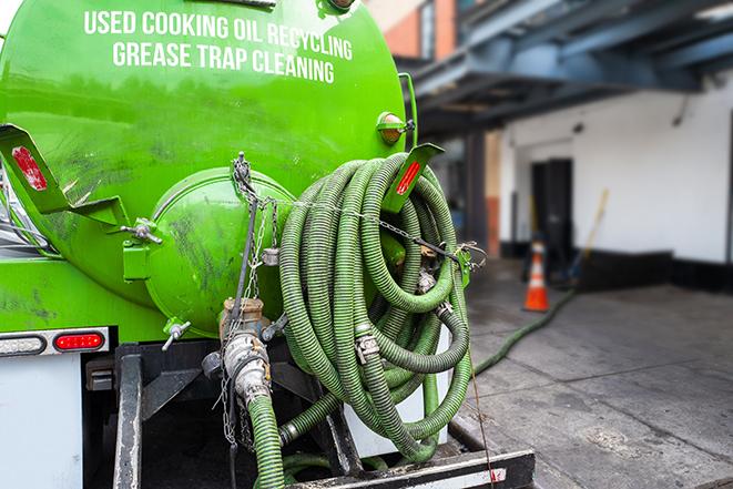 a grease trap being pumped by a sanitation technician in Venango